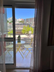 uma janela com vista para uma mesa e cadeiras em The Green House em Lisboa
