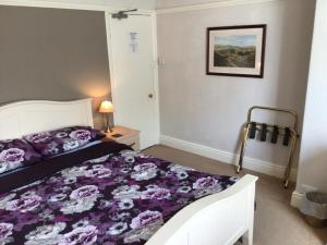 a bedroom with a bed with a purple comforter at Southbourne Guest House in Llandudno