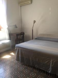 a bedroom with a bed and a table and a window at La villetta Blue in Palermo