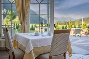 a dining room table with a white table cloth and chairs at Hotel Bad Salomonsbrunn in Anterselva di Mezzo
