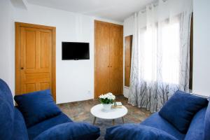a living room with blue couches and a table at Torre Buen Aire cerca de Valencia, con jacuzzi y barbacoa in Benafer