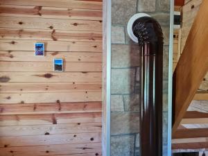 a wood paneled wall next to a spiral staircase at Guest House Rankić in Mokra Gora