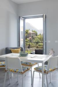 una sala da pranzo con tavolo e sedie bianchi e una finestra di AA Residence - free private parking a Sarno