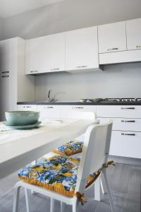 a white kitchen with a table and a chair at AA Residence - free private parking in Sarno