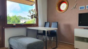レリクにあるFerienhaus mit DDR-Charme an der Ostsee und Salzhaffのテーブルと椅子2脚、窓が備わる客室です。