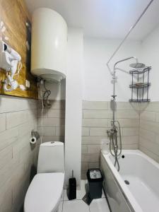 a bathroom with a toilet and a bath tub at Mitarbi Silence - cozy holiday cottages in mountains in Borjomi