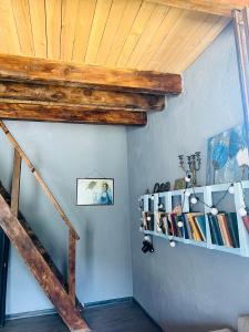 a room with a wooden ceiling and a shelf with books at Mitarbi Silence - cozy holiday cottages in mountains in Borjomi