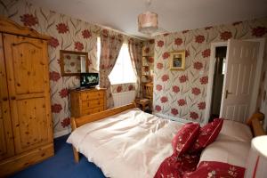 a bedroom with a bed with white sheets and red pillows at Evergreen Bed & Breakfast in Swords