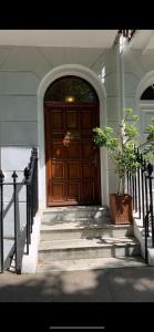 a wooden door on a house with a potted plant at spacious Knightsbridge flat in London