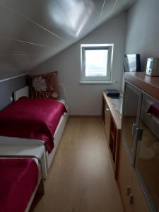 ein kleines Schlafzimmer mit einem Bett und einem Fenster in der Unterkunft Ferienwohnung Sonnenschein in Neuwied