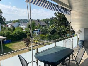 a table and chairs on a balcony with an umbrella at Ferienwohnung Sonnenschein in Neuwied