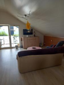 ein Wohnzimmer mit einem Sofa und einem TV in der Unterkunft Ferienwohnung Sonnenschein in Neuwied
