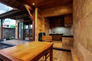 uma cozinha com uma mesa de madeira num quarto em Villa Emerald: Precious Find in the Central Ubud em Ubud
