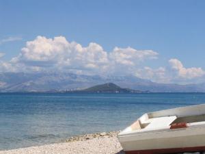 łódź siedząca na plaży w pobliżu wody w obiekcie Apartments in Villa TOP TROGIR w Trogirze