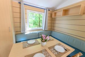 a small dining room with a table and a window at Mobil-home le ROBINSON in Mirgaudon