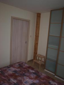 een slaapkamer met een bed, een deur en een kruk bij Dalimilka in Litoměřice