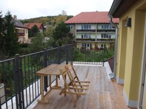 y balcón con mesa y sillas de madera. en Dalimilka, en Litoměřice