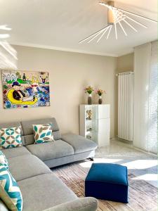 un soggiorno con divano grigio e sgabello blu di Villa Anastasia a Forte dei Marmi