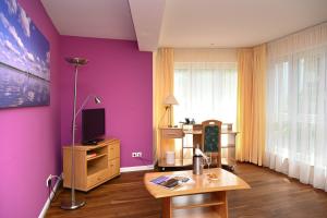 ein Wohnzimmer mit lila Wänden und einem Holztisch in der Unterkunft Hotel Restaurant Luise in Badenweiler