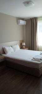 a large bed in a bedroom with a window at Swan Bay complex in Chernomorets