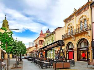 a street with tables and chairs on a city street at Centar lux 2 in Zrenjanin