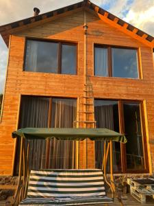 a house with a green table in front of it at Mitarbi Silence - cozy holiday cottages in mountains in Borjomi