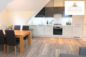 een keuken en eetkamer met een houten tafel en stoelen bij Exclusive Accommodation Free Parking AL10 Hatfield Galleria University free Wi-Fi by White Orchid Property Relocation in Hatfield