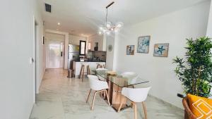 プンタ・カナにあるLuxury Apartment With Pool And Golf Viewのダイニングルーム、キッチン(ガラスのテーブル、椅子付)