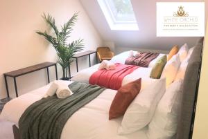 2 bedden in een kamer met witte lakens en kussens bij Exclusive Accommodation Free Parking AL10 Hatfield Galleria University free Wi-Fi by White Orchid Property Relocation in Hatfield