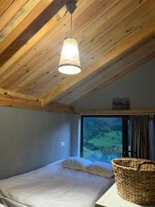a bedroom with a bed and a ceiling with a window at Mitarbi Silence - cozy holiday cottages in mountains in Borjomi