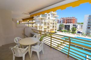 balcón con mesa, sillas y piscina en DIFERENTFLATS Novelty, en Salou