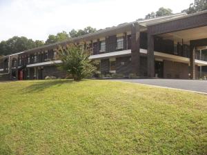 a building with a green lawn in front of it at Lakeside Inn in Guntersville