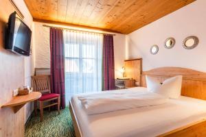 Postel nebo postele na pokoji v ubytování Das Maximilian - Feines Landhotel am Schliersee