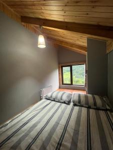 a bedroom with two beds and a window at Mitarbi Silence - cozy holiday cottages in mountains in Borjomi