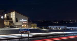 a building on the side of a road at night at Motel Panorama in Šiauliai