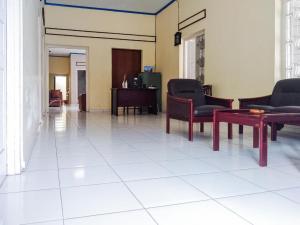 un vestíbulo con sillas y mesas en un edificio en RedDoorz Syariah At Griya Soeratin Pacitan en Pacitan