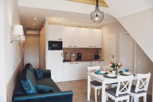 a living room and kitchen with a table and chairs at Apartamenty Wrzosowa in Dębki