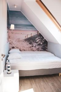 a bed in a room with a beach mural at Apartamenty Wrzosowa in Dębki