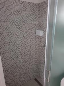 een badkamer met een douche en een betegelde muur bij Apartmani Sain Tribunj in Tribunj