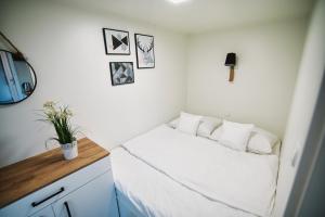 a small bedroom with a bed with white sheets at Skandynawia Przystań in Zator