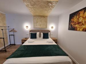 1 dormitorio con 1 cama grande y una pintura en la pared en Bella Vista Bungalow en Turda