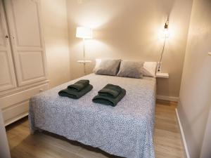 a bedroom with a bed with two green towels on it at II Apartamento moderno y céntrico en Castellón in Castellón de la Plana