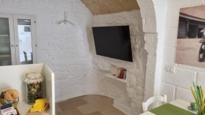 a stone wall with a tv on a wall at 30 Metri Quadri in Ostuni