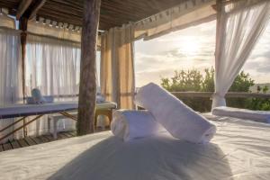 a towel laying on top of a bed on a porch at Zona Braza Beach Lodge in Chizavane