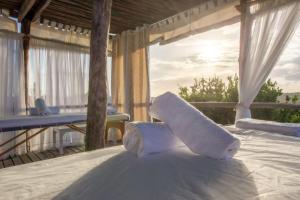 - une serviette installée au-dessus d'un lit sur une terrasse couverte dans l'établissement Zona Braza Beach Lodge, à Chizavane