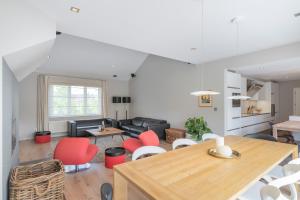 a living room with a table and red chairs at Ruime woning met grote omheinde tuin in Hasselt