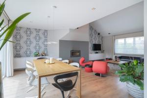 a living room with a dining room table and chairs at Ruime woning met grote omheinde tuin in Hasselt