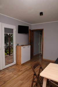 a living room with a table and a television on the wall at B10 Pan i Pani Żuraw nad Jeziorem in Ełk
