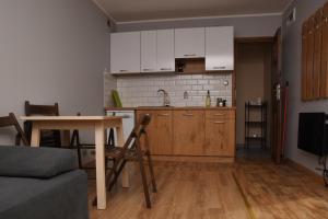 a kitchen with white cabinets and a table and a table at B10 Pan i Pani Żuraw nad Jeziorem in Ełk +11 photos