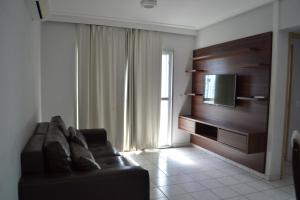 sala de estar con sofá y TV de pantalla plana en Apartamento Aquarius Residence, en Caldas Novas